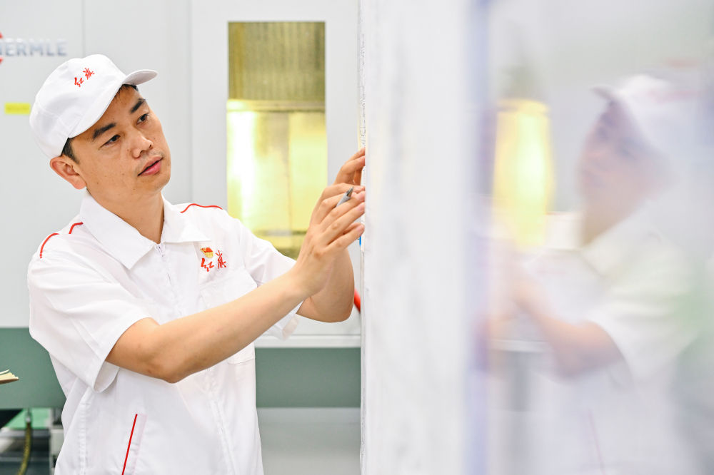 2023年6月8日，一汽研發(fā)總院首席技能大師楊永修查看發(fā)動(dòng)機(jī)圖紙細(xì)節(jié)。新華社記者 許暢 攝