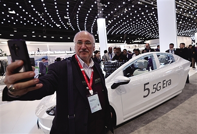 2月28日，在西班牙巴塞羅那舉行的2024年世界移動通信大會上，一名參觀者在華為展臺一輛無人駕駛汽車前自拍。新華社記者 高靜 攝