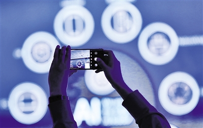 日前在西班牙巴塞羅那舉行的2024年世界移動通信大會上，與會者在“算力網(wǎng)絡(luò)：智能網(wǎng)絡(luò)賦能智慧世界”專題論壇上拍攝關(guān)于AI內(nèi)容的幻燈片。新華社記者 高靜 攝